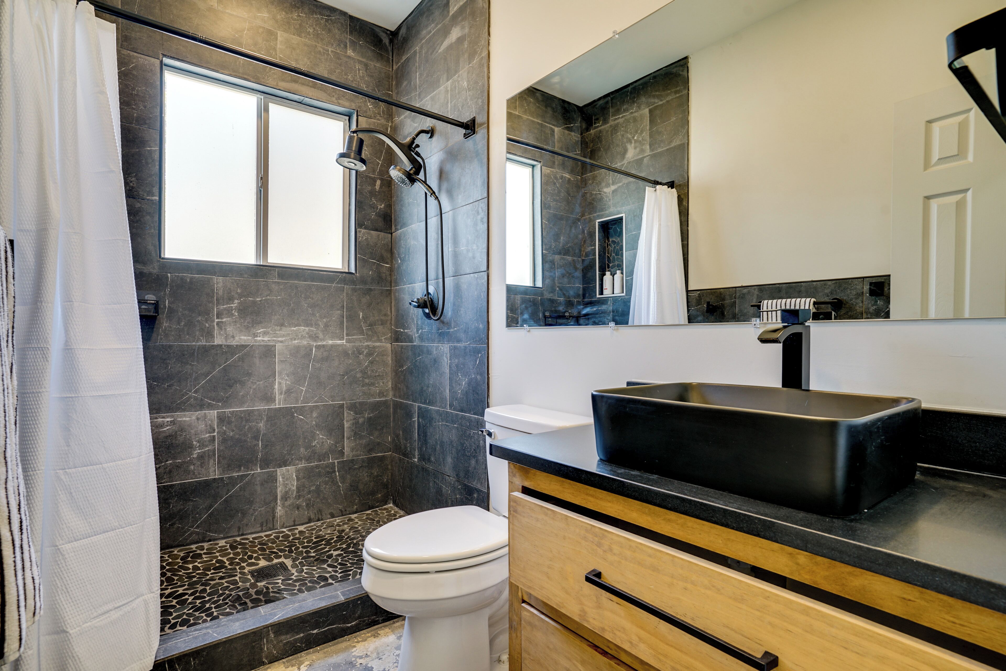Ein modernes Badezimmer mit Dusche, Toilette und Waschbecken.