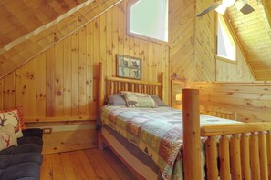 A wooden cabin bedroom with a bed, a window, and a loft area. - 1 Mi to Dollywood! Hot Tub Hideaway in Smokies (Sevierville)