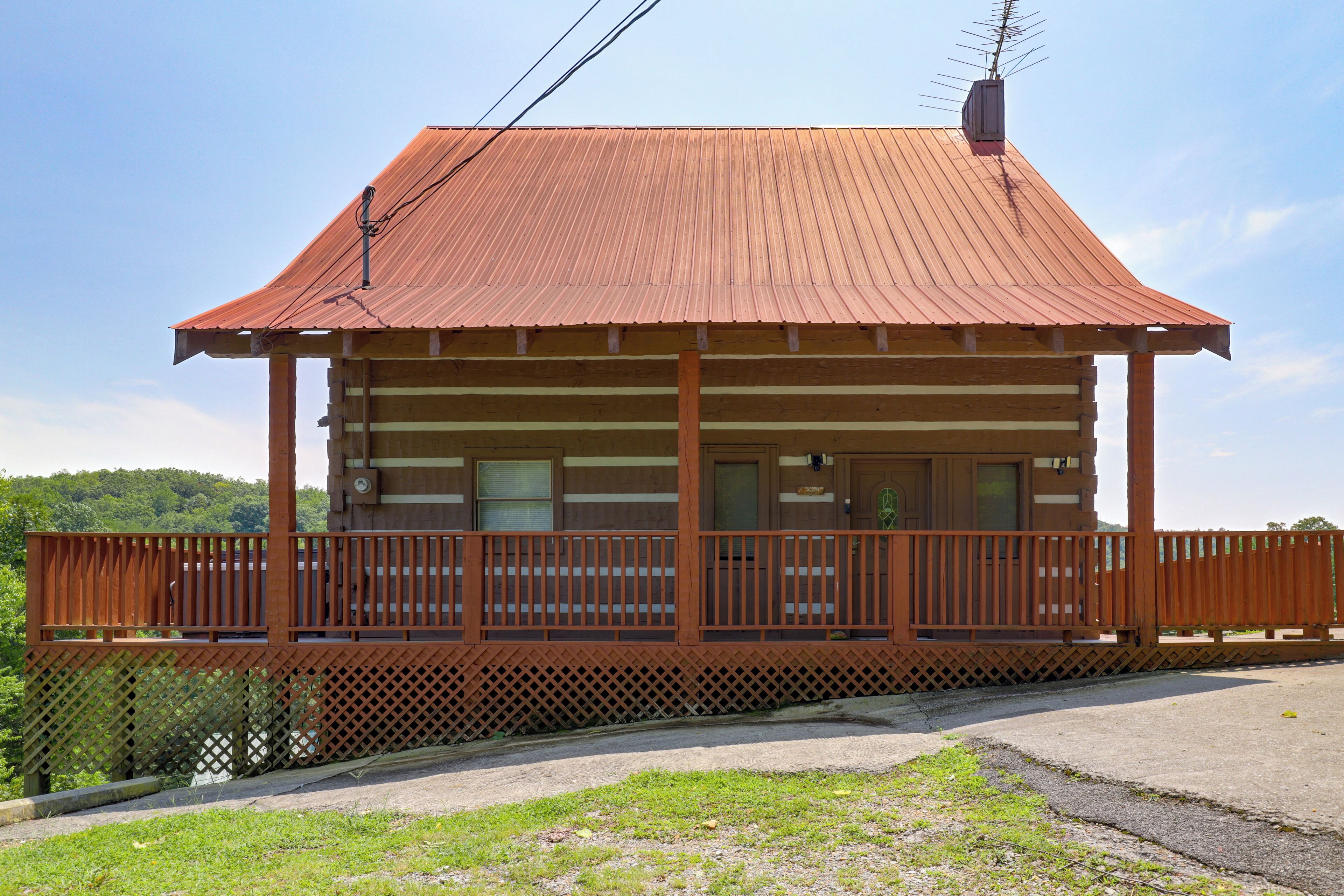 A wooden cabin with a balcony, a window, and a door.
