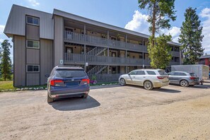 Ein mehrgeschossiges Gebäude mit Parkplatz davor.