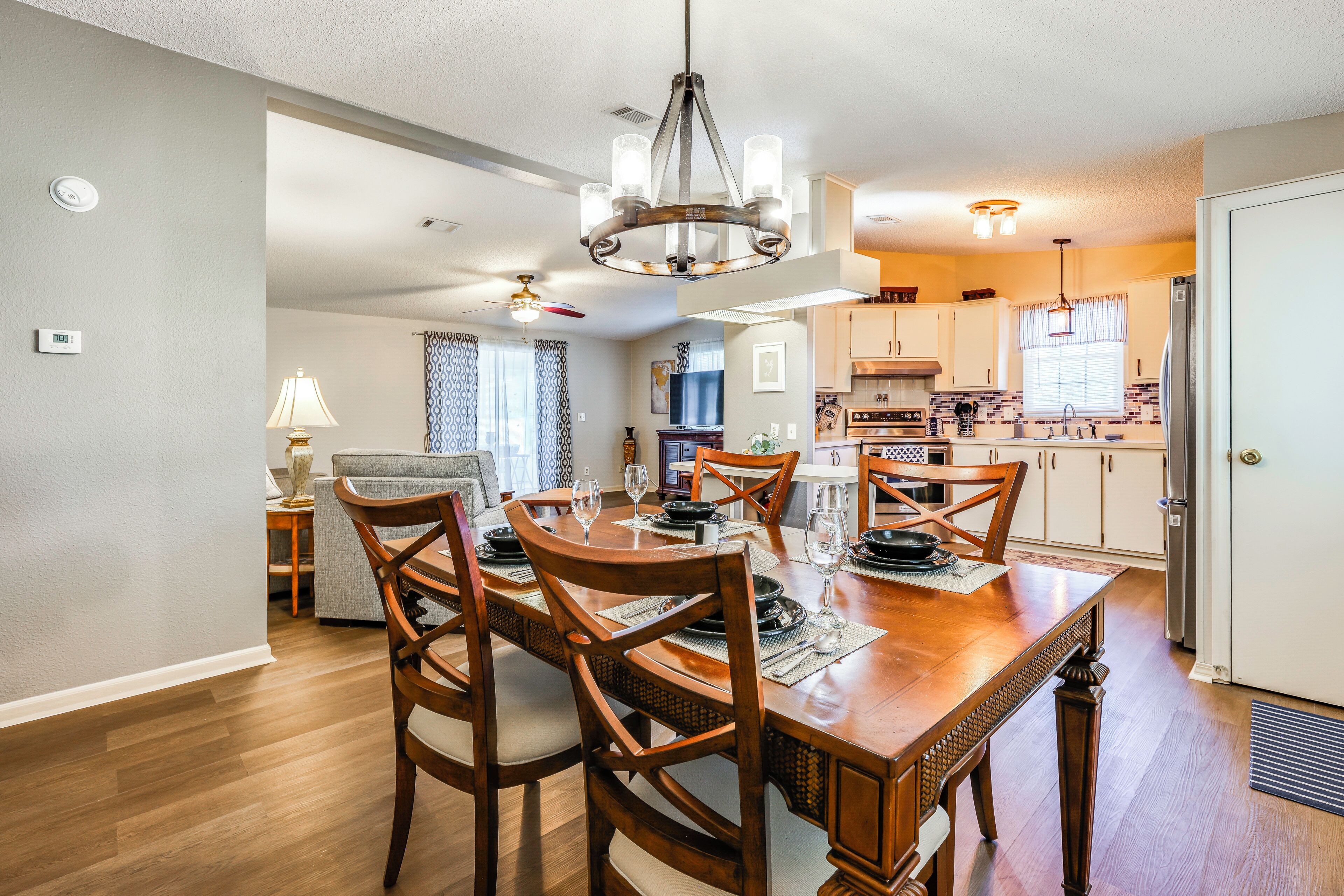 A dining area with a wooden table, chairs, and a chandelier.