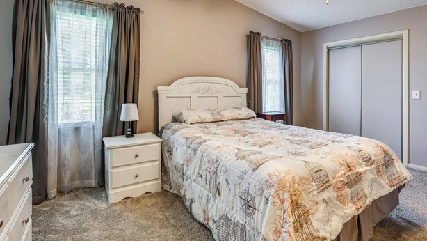 Ein Schlafzimmer mit Bett, Nachttisch, Kommode und Schrank.