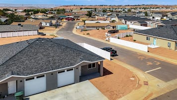 A residential area with houses, a road, and a distant hill.