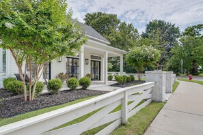 A two-story house with a covered porch, a white fence, and a well-maintained lawn. - Walkable Rose District Retreat! 15 Mi to Tulsa (Broken Arrow)