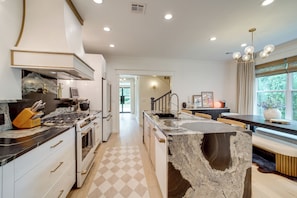A modern kitchen with a central island, stainless steel appliances, and a view to the dining area.