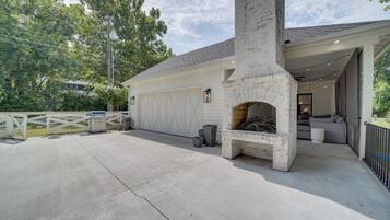Een huis met een garage, een barbecue en een stenen openhaard.