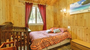 Ein Zimmer mit Holzboden, einem Bett, einem Schreibtisch und einem Stuhl.