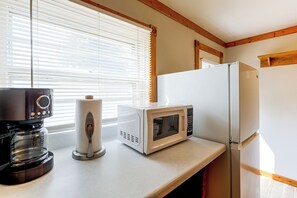 A kitchen with a coffee maker, paper towel holder, and a microwave on the counter. - Walk to Park & Creek! Spearfish Couples Retreat (Spearfish)