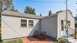 A single-story house with a patio area featuring a table and two chairs. - Walk to Park & Creek! Spearfish Couples Retreat (Spearfish)