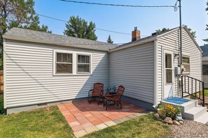 A single-story house with a patio area featuring a table and two chairs. - Walk to Park & Creek! Spearfish Couples Retreat (Spearfish)