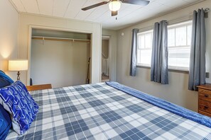 A bedroom with a bed, a nightstand, a lamp, a closet, and a window with curtains. - Walk to Park & Creek! Spearfish Couples Retreat (Spearfish)