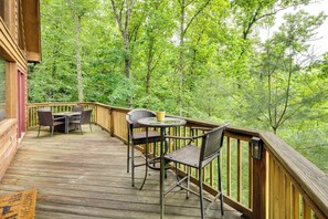 Eine Holzterrasse mit Gartenmöbeln, umgeben von dichtem Grün.