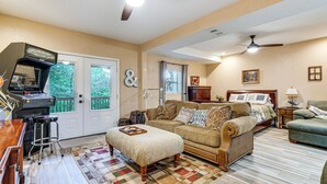 Ein Wohnzimmer mit Sofa, Hocker und Deckenventilator.