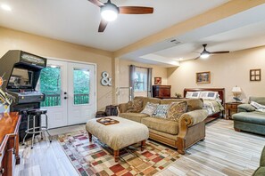 Ein Wohnzimmer mit Sofa, Hocker und Deckenventilator.