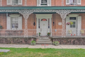 A brick building with a white door and windows, a green awning, and a sign that reads 'McCausland Mansion.' - Hike, Golf & Explore! Family Gem in Dtwn Bedford (Bedford)