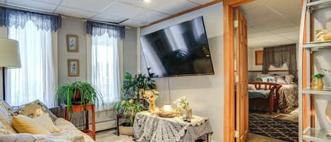 Un salon avec un canapé, une table basse et un téléviseur fixé au mur.