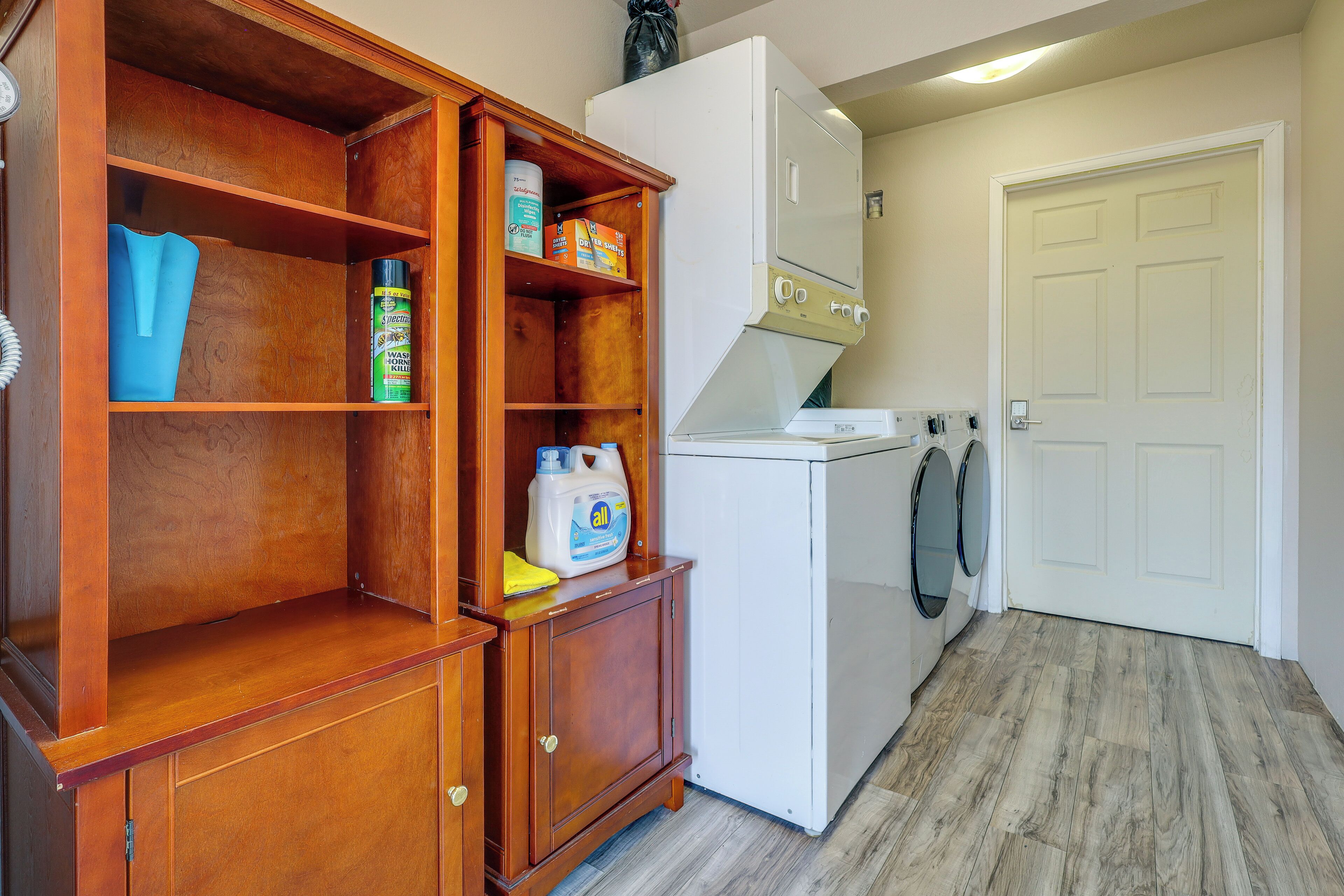 A compact kitchen with a wooden cabinet, a white refrigerator, and a door.