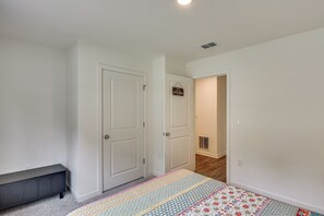 Ein Zimmer mit Tür, einer Bank, einem Teppich und einem Schild an der Wand.