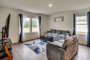 A living room with a grey sofa, a coffee table, and a TV on a stand.