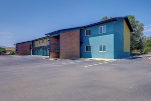 A multi-story building with a parking lot in front.