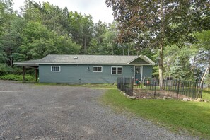 A single-story house with a gravel driveway and a fenced yard. - Deck & Stunning Views! Family Getaway in Hamilton (Hamilton)