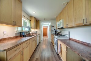 A kitchen with wooden cabinets, a microwave, a stove, and a dishwasher.
