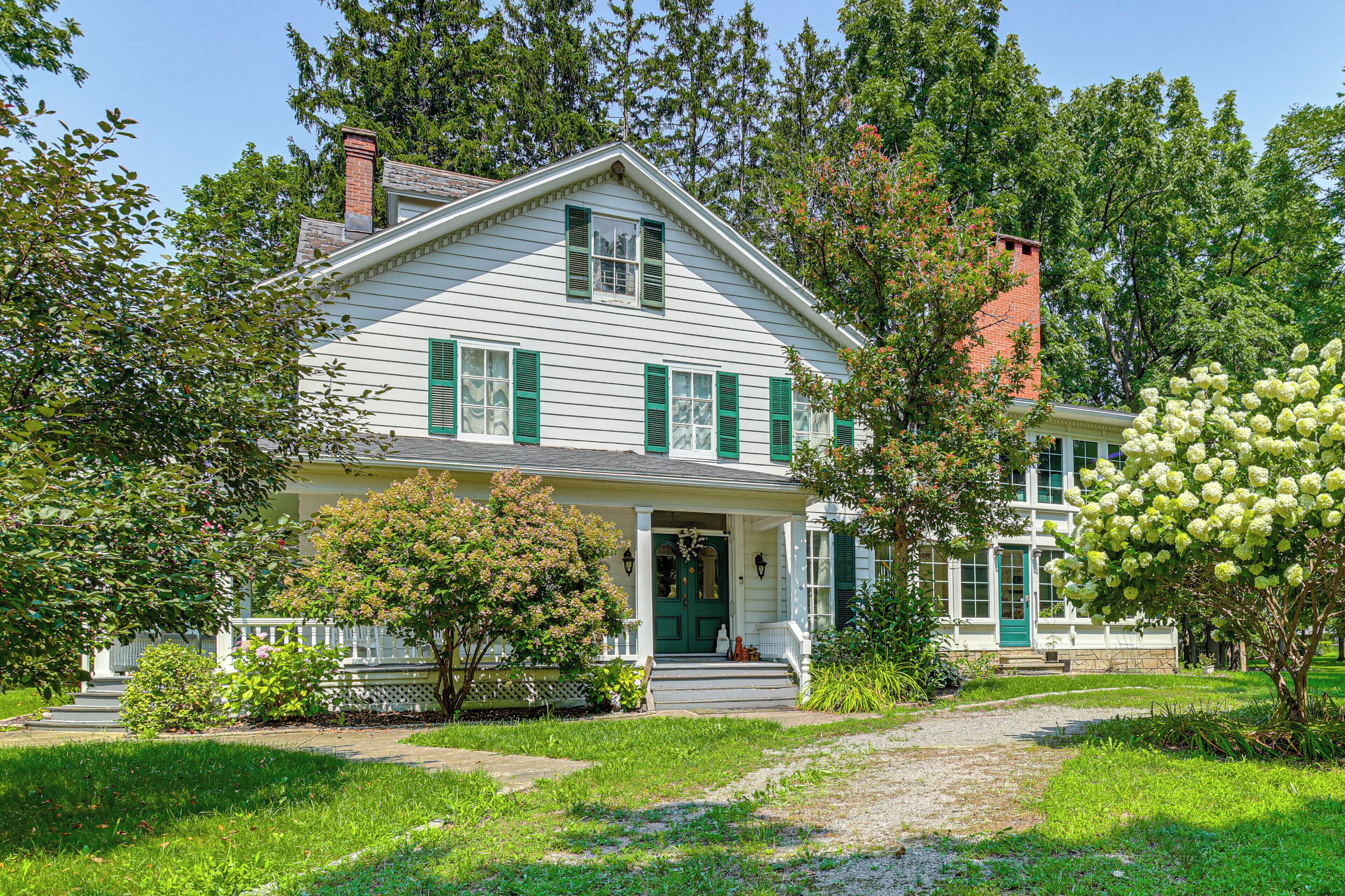A two-story house with a front porch, a chimney, and a well-maintained lawn.