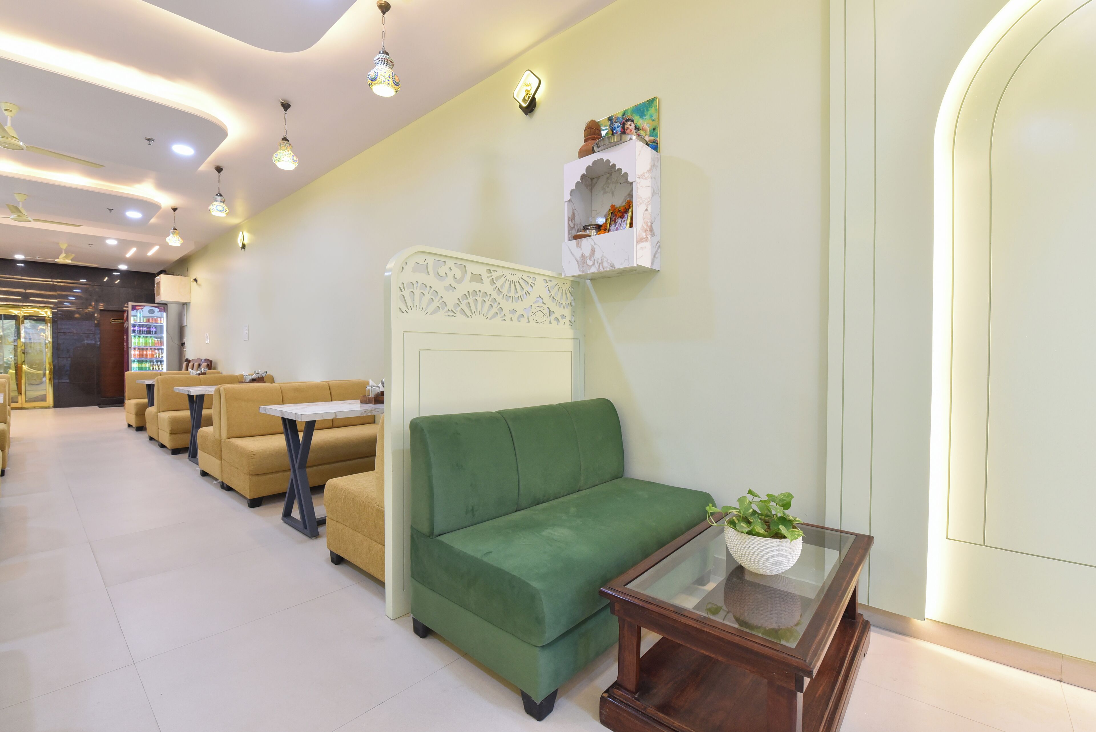 A hotel lobby with seating areas, a reception desk, and a decorative wall piece.