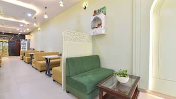 A hotel lobby with seating areas, a reception desk, and a decorative wall piece.
