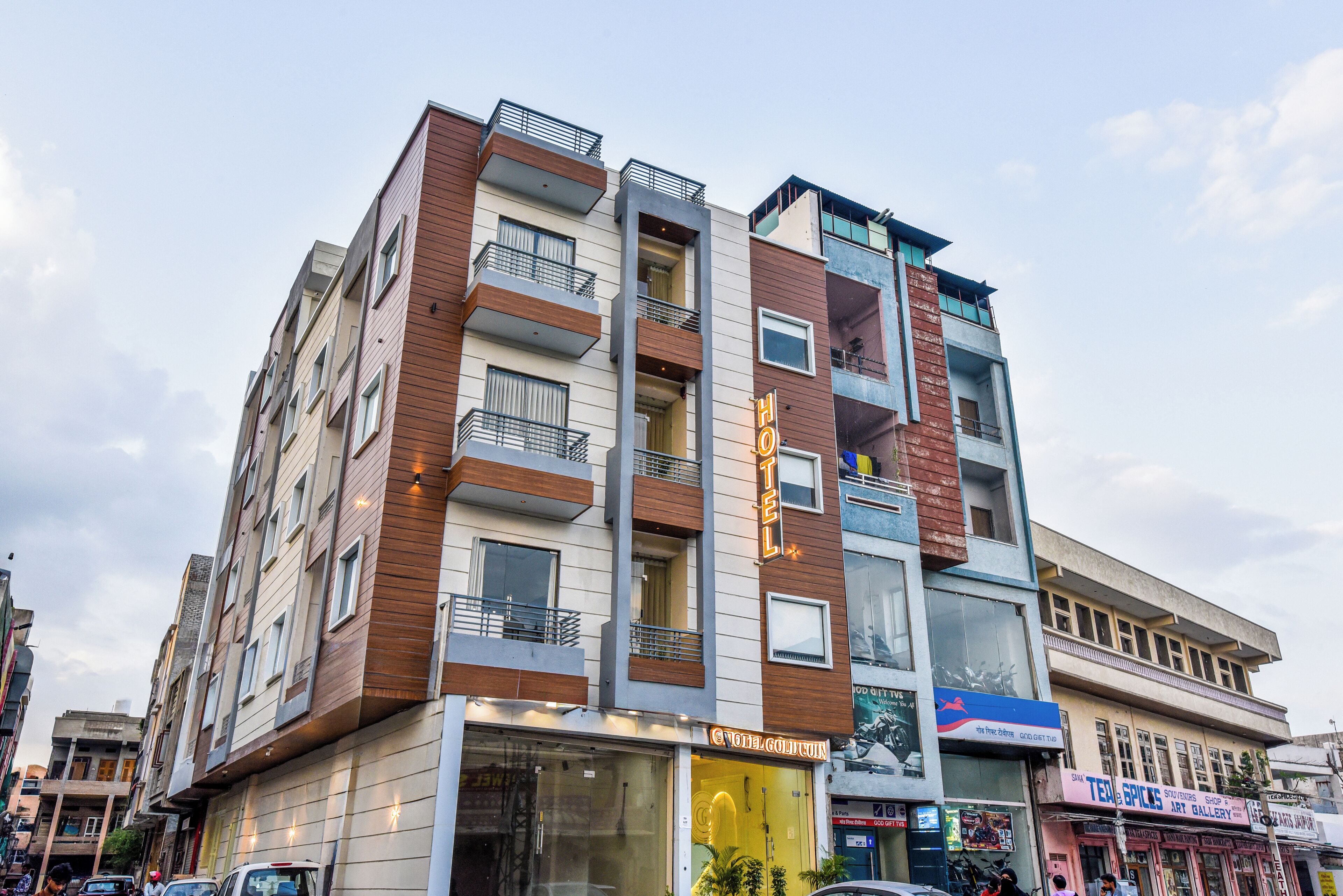 Un hotel de varios pisos con balcones, una tienda en la planta baja y una entrada visible.