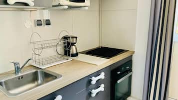 A kitchen with a microwave, sink, and stove.
