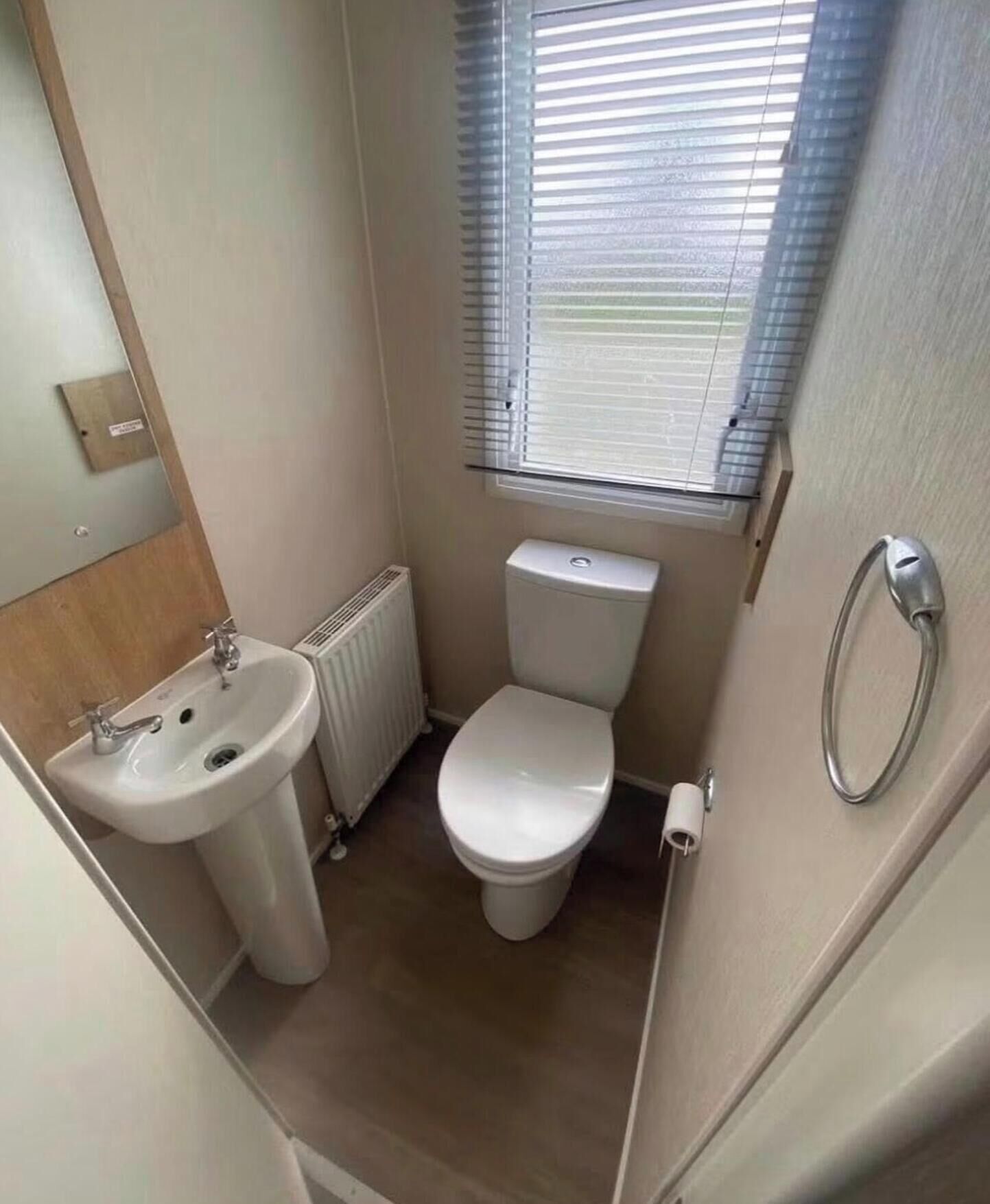 Une petite salle de bain comprenant un lavabo, des toilettes et une fenêtre.