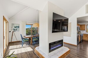 A modern living room with a fireplace, dining area, and kitchen. - New Listing, Private Pool, Hot Tub, Walk to Beach, Dogs Welcome C0919 (Corolla)