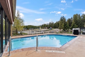 A swimming pool with a metal railing, surrounded by a fence, and a clear sky. - Ski-Inspired Mountain Getaway Steps from Peak 9 and Main Street! (Breckenridge)