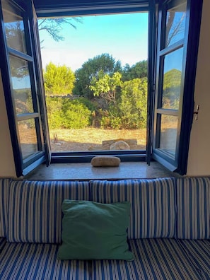 A room with a window seat overlooking a garden. - Authentic Sardinian house 100 m from the sea (Carloforte)