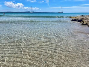 A beach with clear shallow waters and two sailboats in the distance. - Authentic Sardinian house 100 m from the sea (Carloforte)