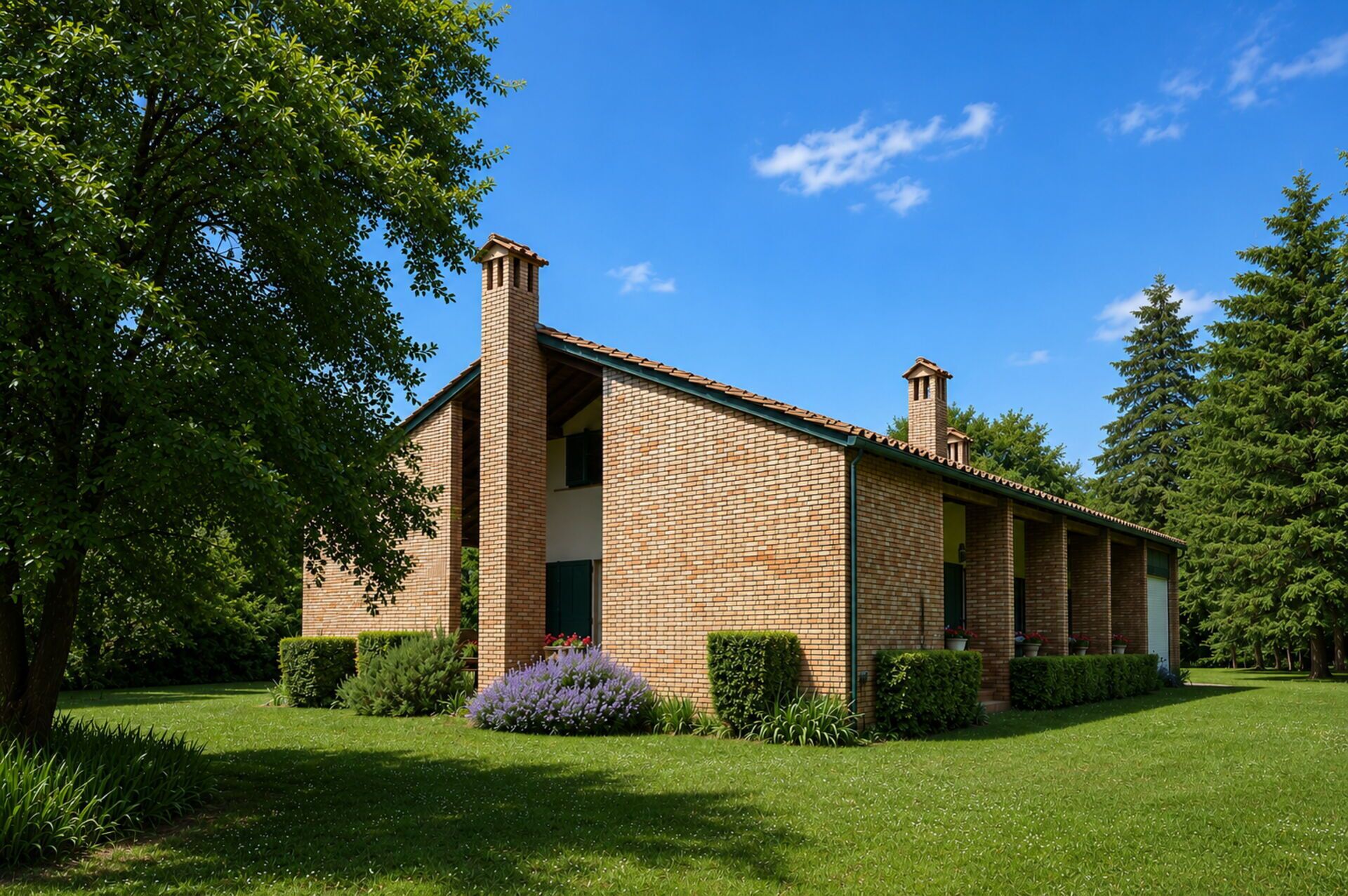 A brick building with a central chimney, surrounded by a well-maintained lawn and trees.