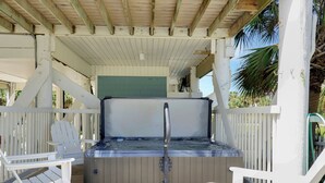 A hot tub with a wooden deck, white chairs, and a covered area with a wooden ceiling. - Beachfront Home | Hot tub | Pet Friendly | Sea Palms (Indian Pass)