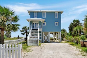 A two-story building with a covered staircase and a white picket fence. - Beachfront Home | Hot tub | Pet Friendly | Sea Palms (Indian Pass)