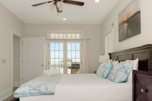 A bedroom with a bed, a ceiling fan, a window with a view, and a door. - Beachfront Home | Hot tub | Pet Friendly | Sea Palms (Indian Pass)