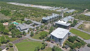 An aerial view of a campus with multiple buildings, green spaces, and a swimming pool. - 🌊Seaside Escape | Windmark Beach | Pool + Beach Access (WindMark Beach)