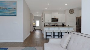 A modern kitchen with white cabinetry, a stainless steel refrigerator, and a microwave. - 🌊Seaside Escape | Windmark Beach | Pool + Beach Access (WindMark Beach)