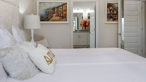 A bedroom with a bed, pillows, a lamp, and two paintings on the wall. - 🌊Seaside Escape | Windmark Beach | Pool + Beach Access (WindMark Beach)