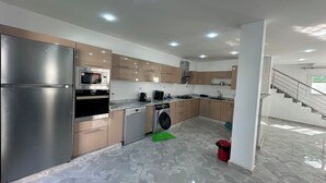 A modern kitchen with stainless steel appliances, a dishwasher, and a washing machine.