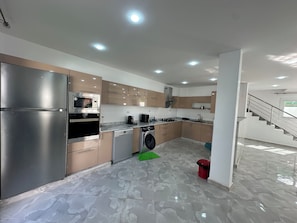 A modern kitchen with stainless steel appliances, a dishwasher, and a washing machine.