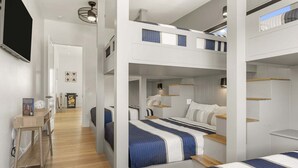 Quarto de hotel moderno com beliches, uma mesa de escritório e um espaço para leitura.
