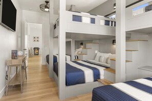 A modern hotel room with bunk beds, a desk, and a reading area. - Lagoon Landing 7 Bedroom Home (St. George)