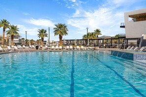 A swimming pool with lounge chairs and palm trees. - Lagoon Landing 7 Bedroom Home (St. George)