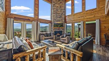 Un salón comedor amplio con chimenea, ventanas grandes y una pared de acento de piedra.