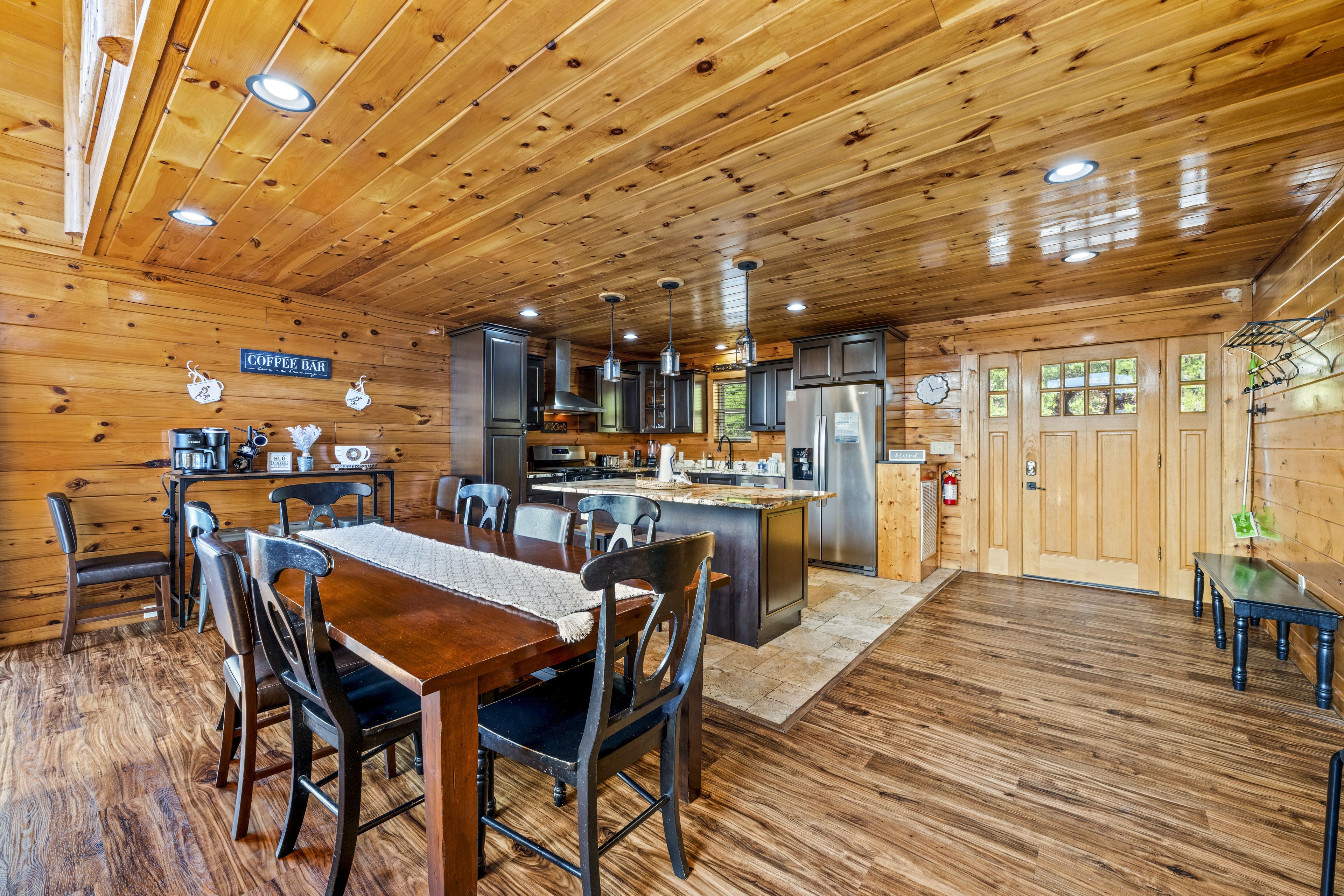 Interior de madera con comedor, cocina y un cartel que indica cafetería.